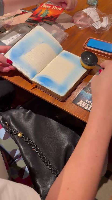 Participante criando um fundo azul nas páginas de um journal.